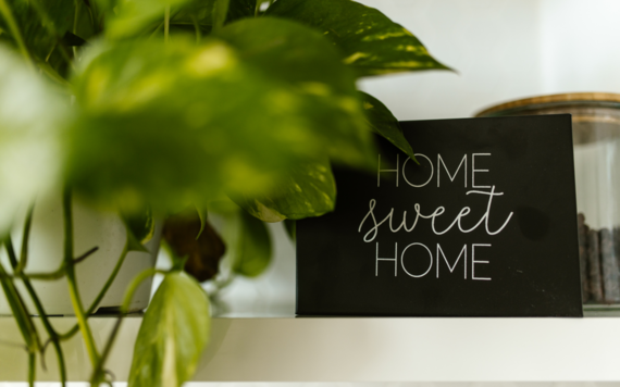 Home sweet home chalkboard sign on a mantlepiece with a plant