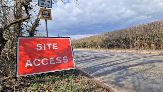 a folding sign that says Site Access next to the roadside outside Wokingham town centre