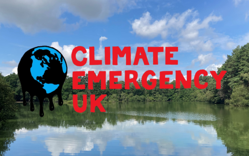 Climate Emergency UK text caption above the background of a lake