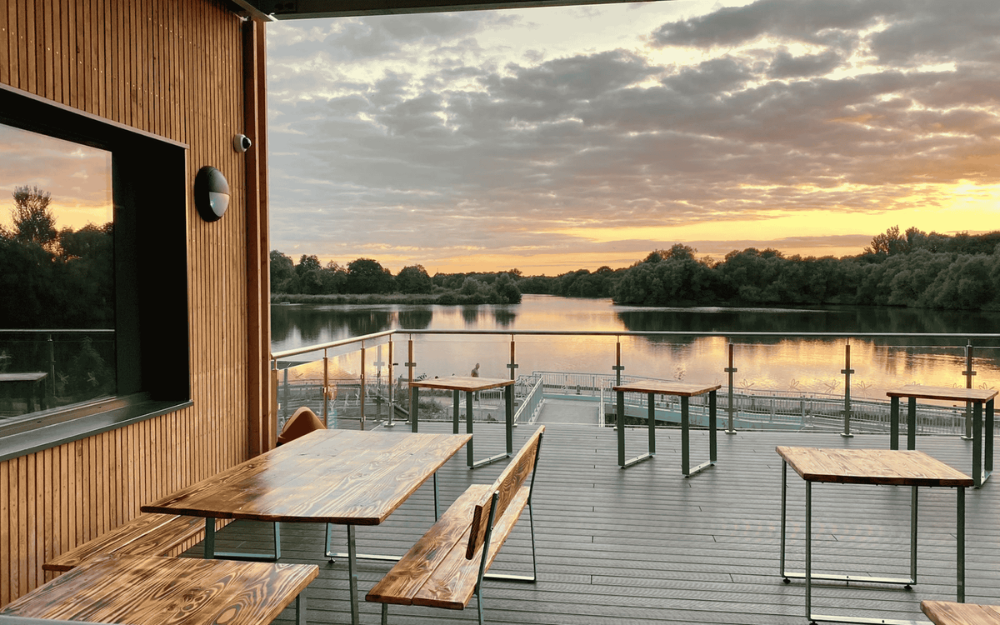 View of the dropping orange sunset at Black Swan Lake at Dinton Pastures from the coffee deck
