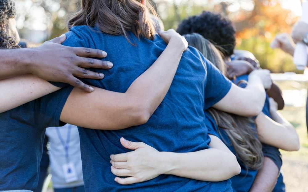 charity workers with arms around eachother