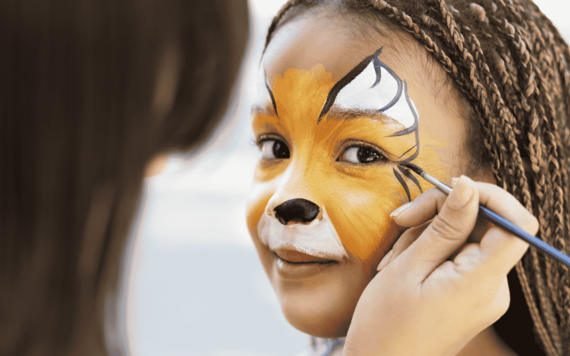 A child with a tiger face paint on