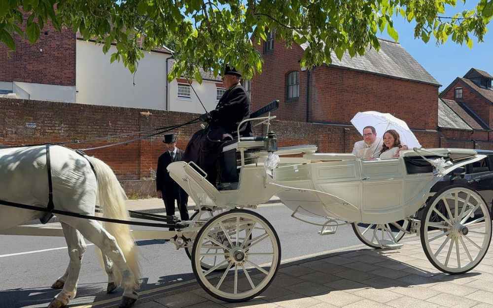Couple in wedding carriage outside Shute End