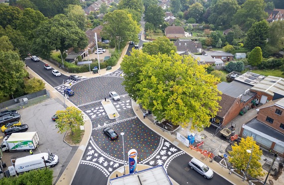 aerial view of a new crossroads with a large shared surface painted with colourful leaves, plus crossings with white leaf designs