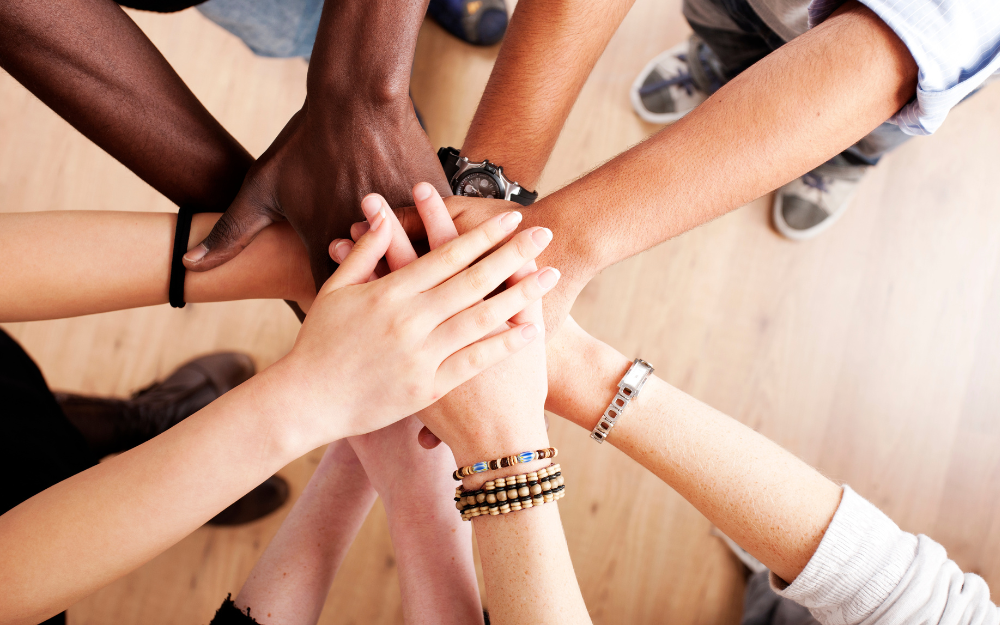 charity volunteers putting their hands all in together