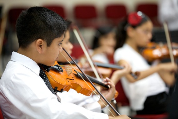Image of a boy playing the violin in his school orchestra