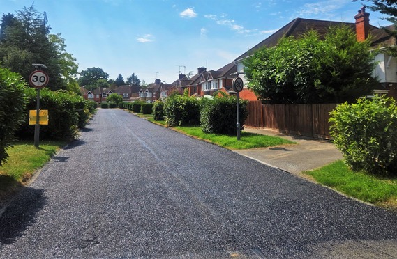 a residentila street after surface dressing, with a new layer of loose stone chippings sitting on top of the existing road