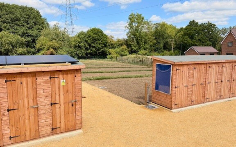 A view of new allotments, with wooden structures and new ground ready to dig