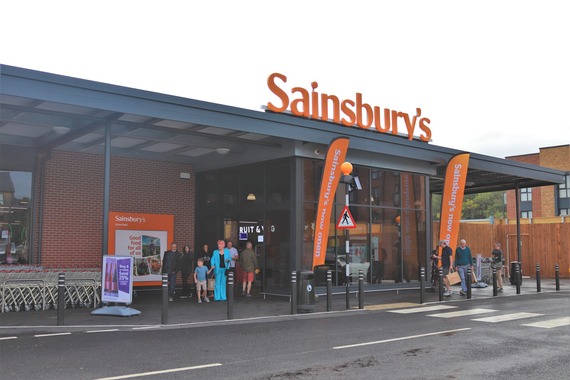 a new single-storey modern supermarket building with Sainsbury's logo in large stencilled plastic letters on the roof