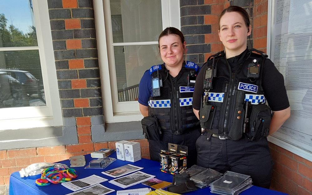 Two police officers at a community event in Twyford, with information desk
