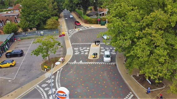 Low aerial shot of California Crossroads, with cars crossing the junction and a cyclist riding on the space alongside it