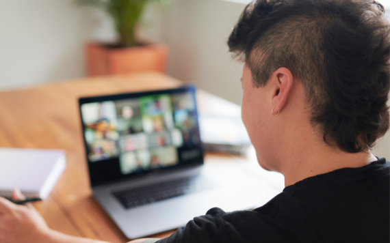 A young person on an online call on a laptop