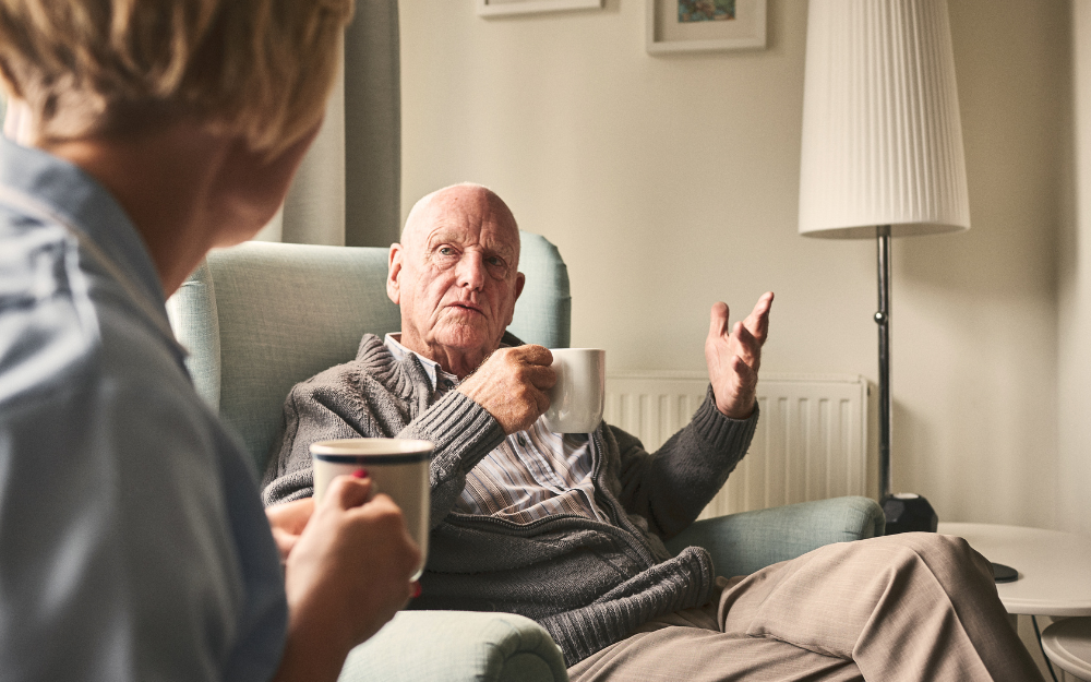 man having cup of tea with family member