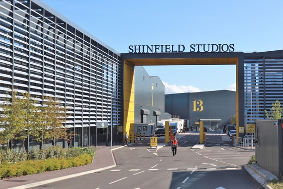 the entrance to Shinfield Studios, with a multi-storey car park and the studio name on a tall metal arch, surrounded by big studio buildings