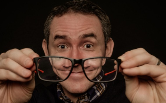 Comedian looking through his glasses