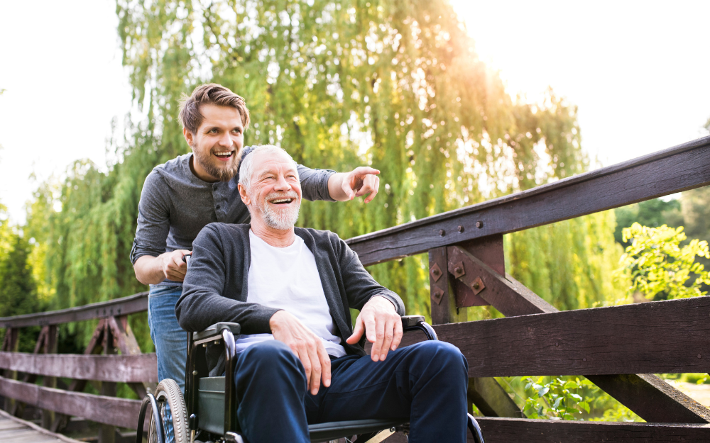 Man pushing elderly man in wheelchair
