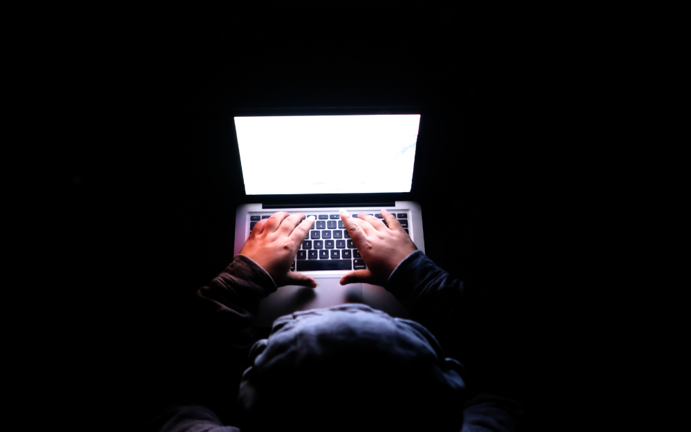 Person using laptop in a dark room