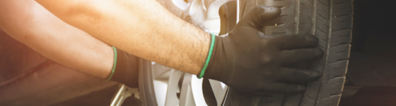 close-up of hands attaching a new tyre to a car