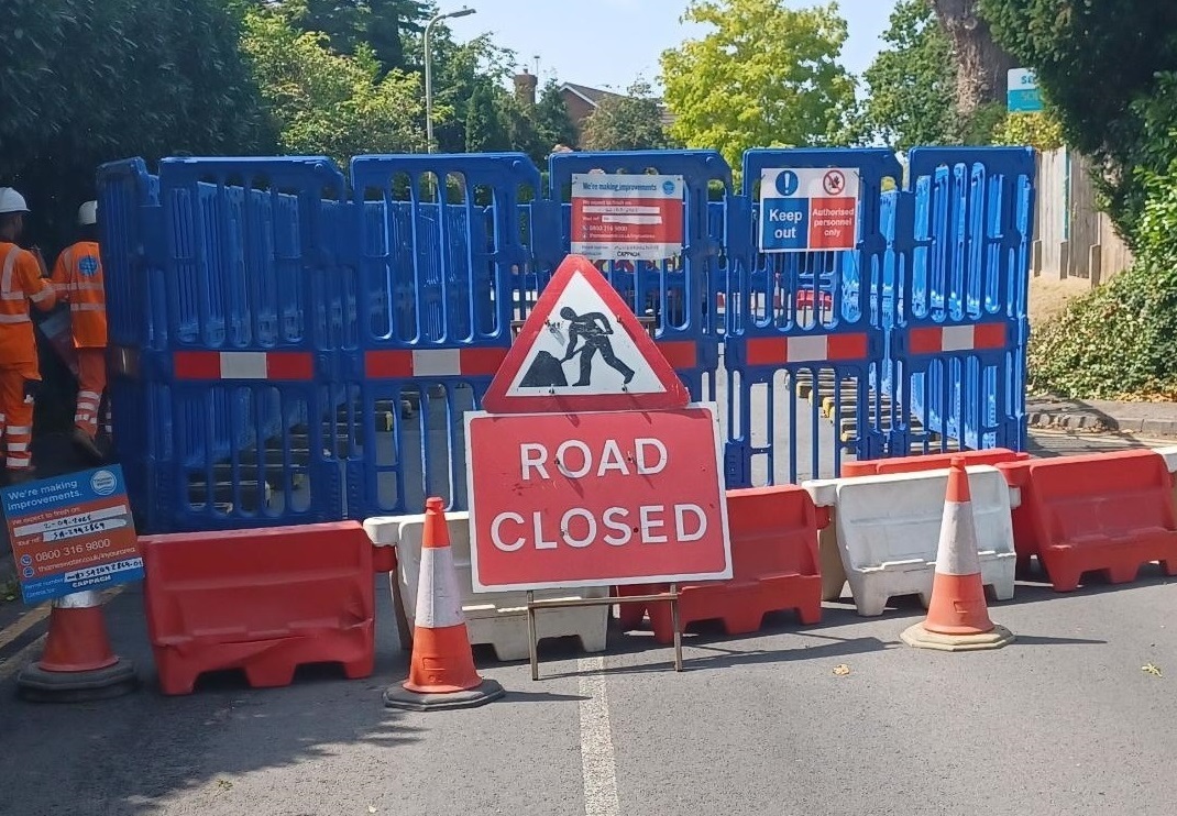 road closure in a residential street with big blue plastic barriers