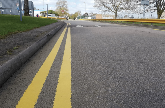 close up of double yellow lines on a road in an industrial estate