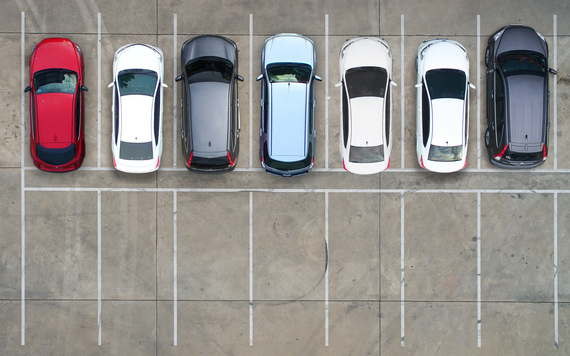 top down view of parking spaces, with about half occupied by parked cars