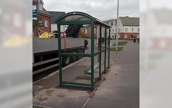 a newly erected bus shelter on a residential street in Shinfield, with concrete setting around it