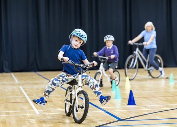 Group of children and instructor being taught how to learn to ride a bike
