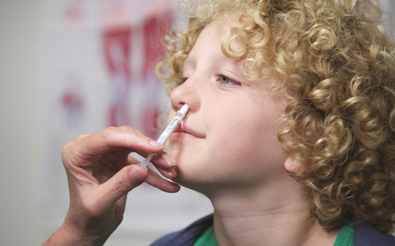 A young boy having a nasal flu vaccine