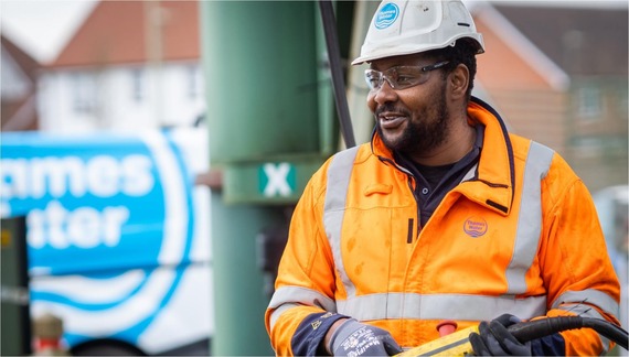 a man in orange high vis overalls and a helmet working on a Thames Water site