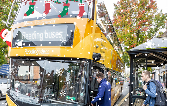 Bus decorated with Christmas decorations and two passengers waiting to board the bus