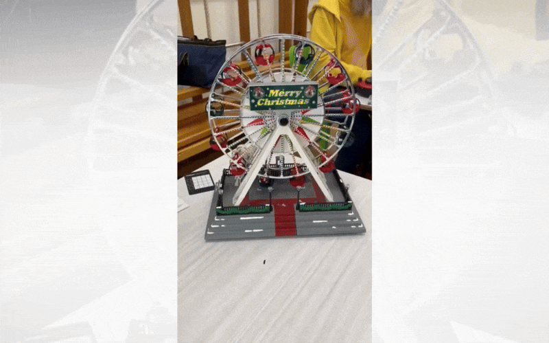 A moving gif image showing a festive Ferris Wheel decoration turning
