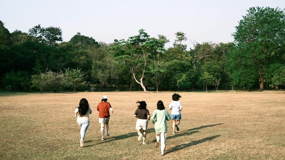 A group of young people walking together across a field