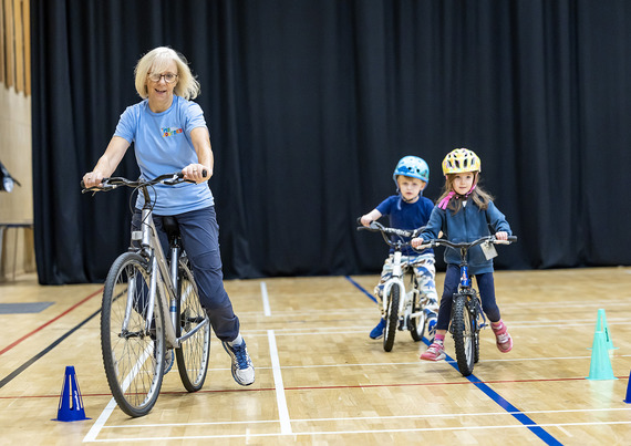 Instructor teaching children how to ride a bike