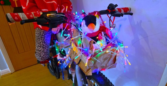 close-up of a child's bike handlebars with multi-coloured lights wrapped around them for the bling your bike competition