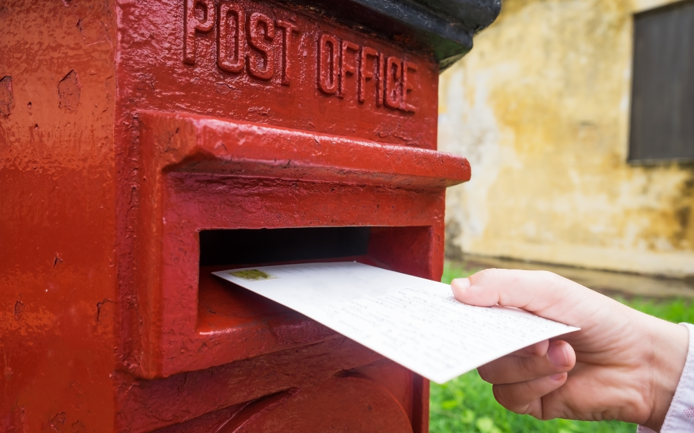 Letter going into a red letter box