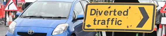 close up of a temporary sign with an arrow saying "Diverted traffic"