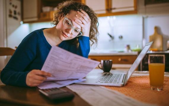 Woman looking through bills with laptop