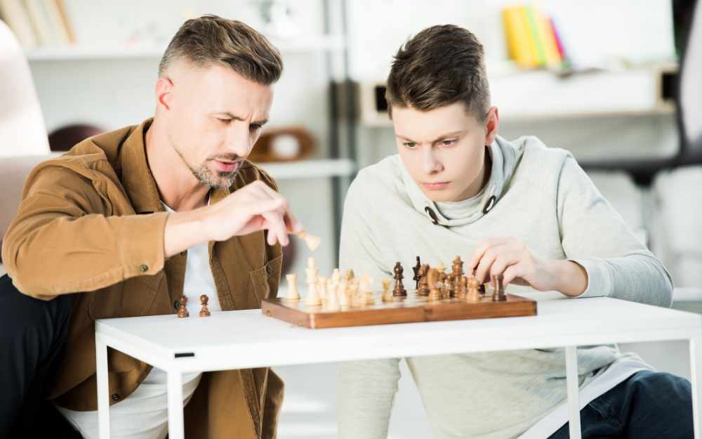 Man and teenager playing chess