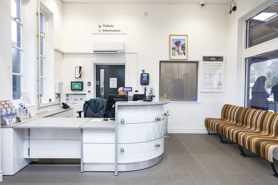 the inside of a railway station ticket office with a bright white open desk for selling tickets