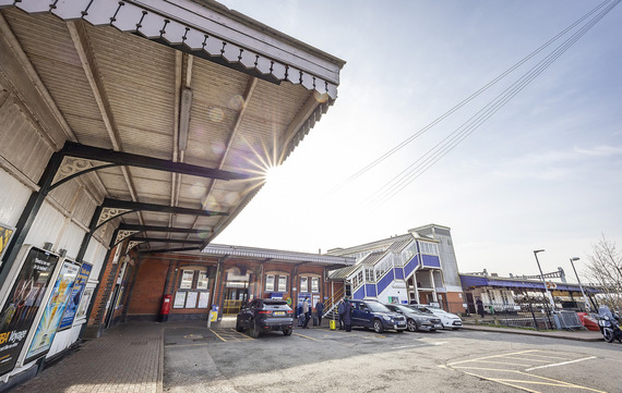 ultra wide shot of the canopies outside the entrance to Twyford station, with the sun rising above them