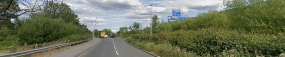 driver's eye view of Hatch Farm Way in Winnersh looking east, with the M4 up on an embankment to the right