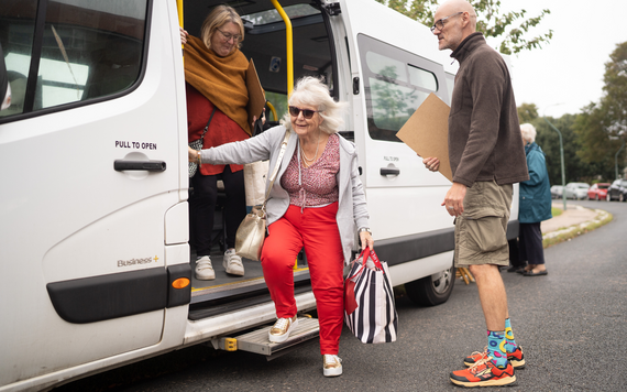 Image of older woman getting off a community transport bus