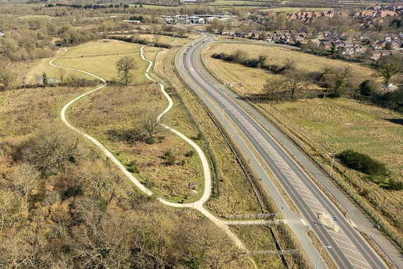 aerial view showing footpaths winding through a pretty park beside a road which has a wide shared footway and cycleway alongside