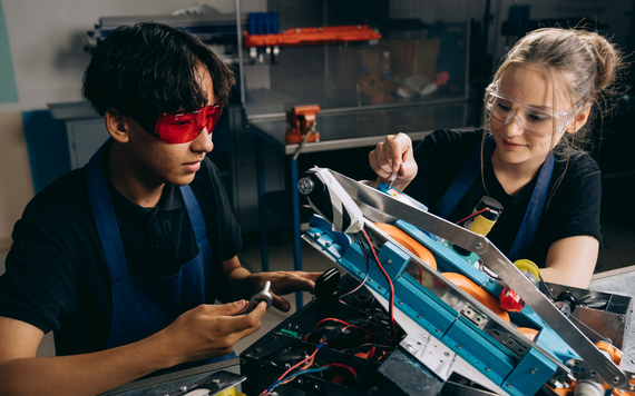 Two young people wiring a machine at college