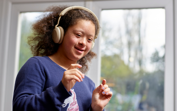Young neurodiverse girl smiling and listening to music