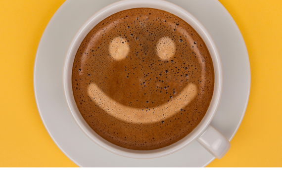 A cup of coffee with smiley face latte art