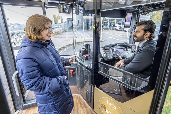 A woman smiles at the bus driver as she walks past him to board a bus in Wokingham town centre
