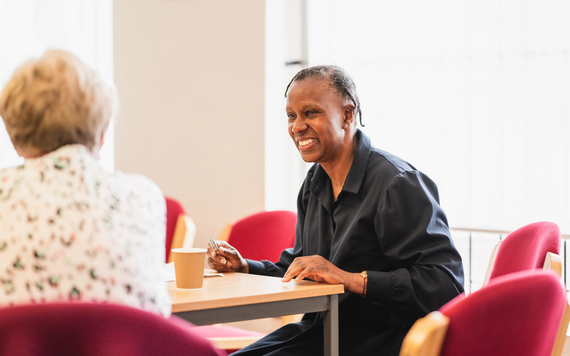 Woman sat at table talking and making notes