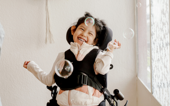 A girl laughing, surrounded by bubbles 