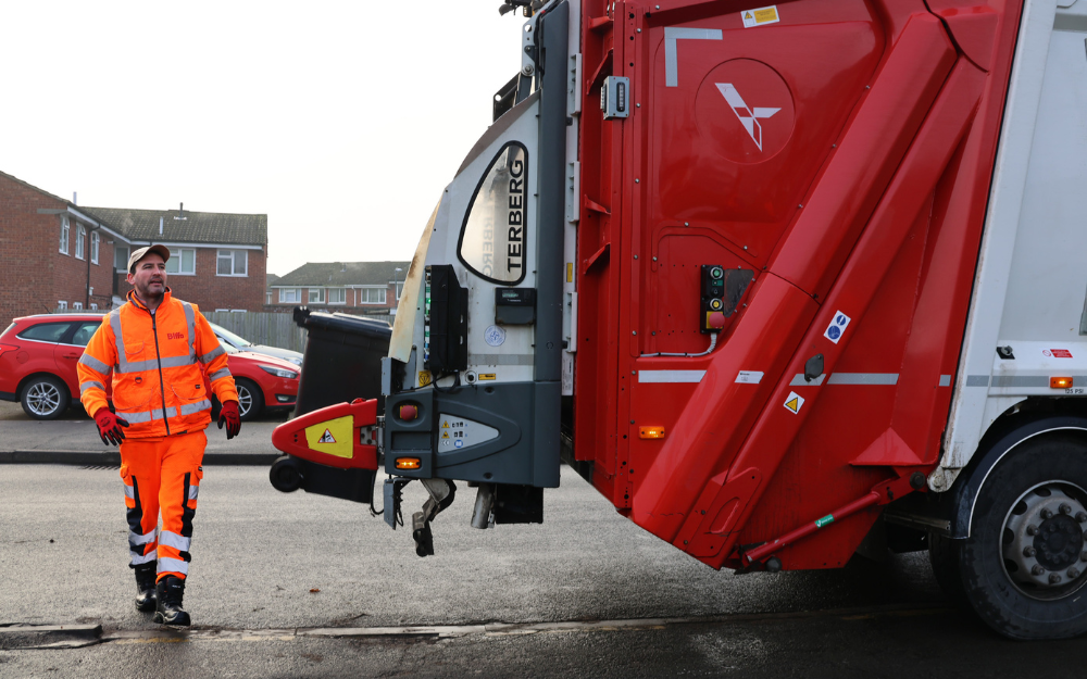 Waste collection crew working behind a collection vehicle